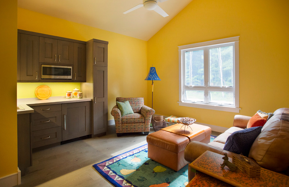 Cette photo montre une petite salle de séjour chic ouverte avec un mur jaune et un sol gris.