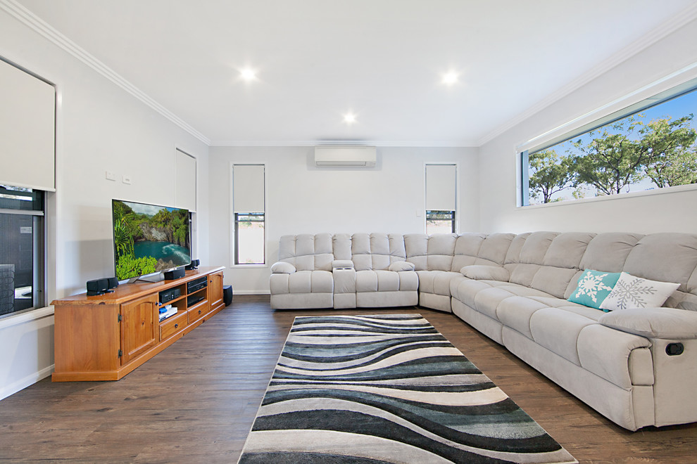 Large minimalist enclosed dark wood floor and brown floor family room photo in Townsville with white walls and a tv stand