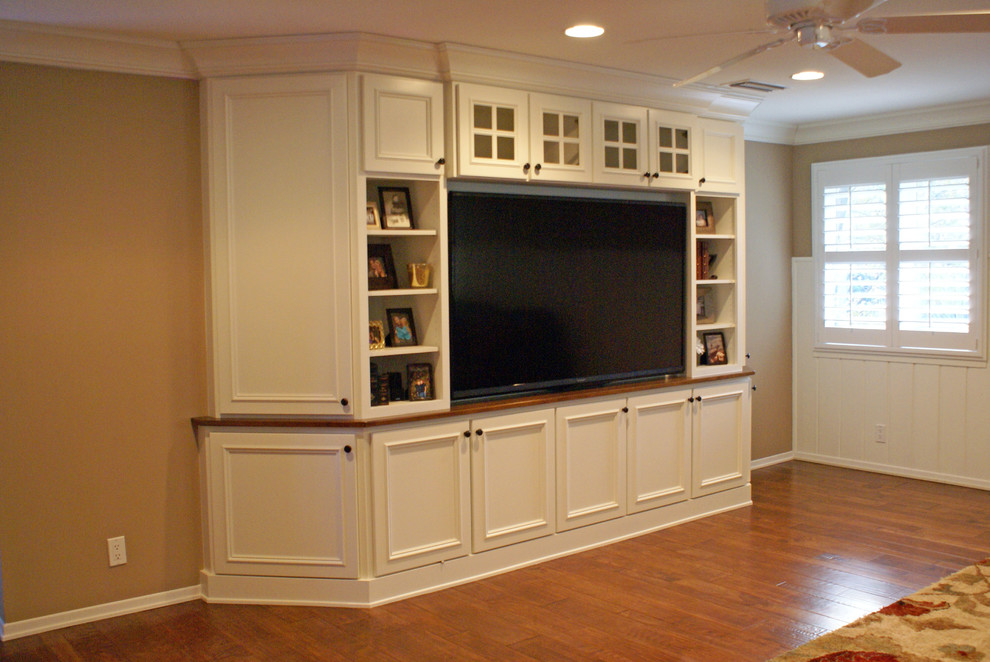 Ispirazione per un grande soggiorno chic aperto con pareti beige, pavimento in legno massello medio e TV a parete