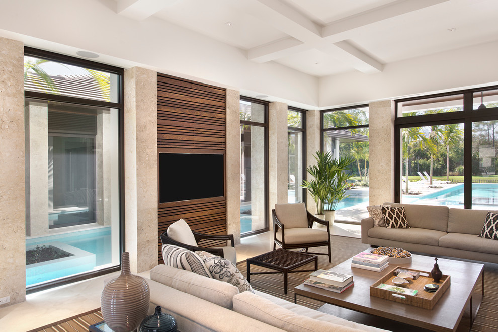 Immagine di un soggiorno design con pareti beige e TV a parete