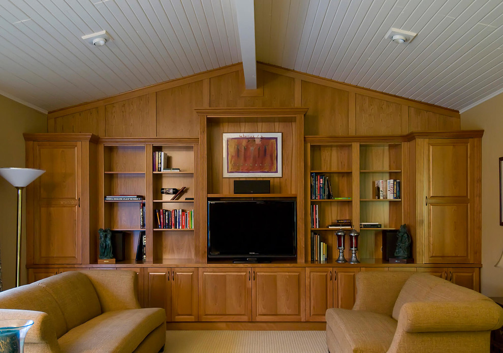 На фото: огромная открытая гостиная комната в классическом стиле с зелеными стенами, отдельно стоящим телевизором, с книжными шкафами и полками, ковровым покрытием и бежевым полом без камина