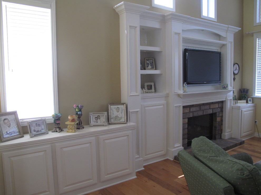 Idée de décoration pour une salle de séjour tradition de taille moyenne et ouverte avec un mur beige et un téléviseur encastré.