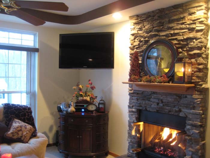 Photo of a medium sized classic enclosed games room in Cleveland with white walls, carpet, a ribbon fireplace, a stone fireplace surround and a corner tv.