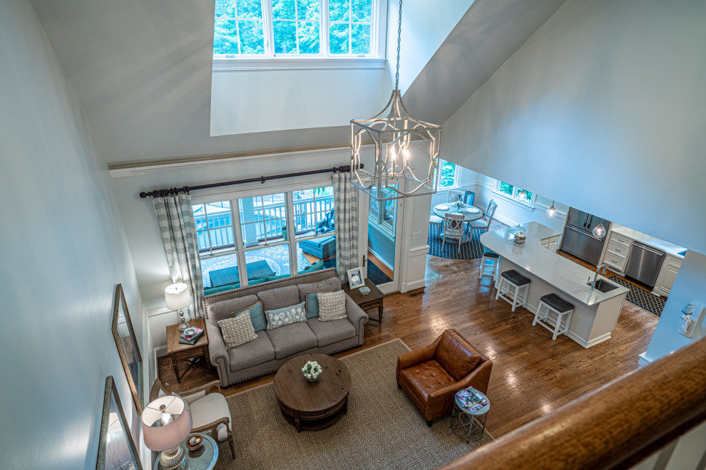 Huge transitional open concept medium tone wood floor and vaulted ceiling family room photo in Atlanta with gray walls