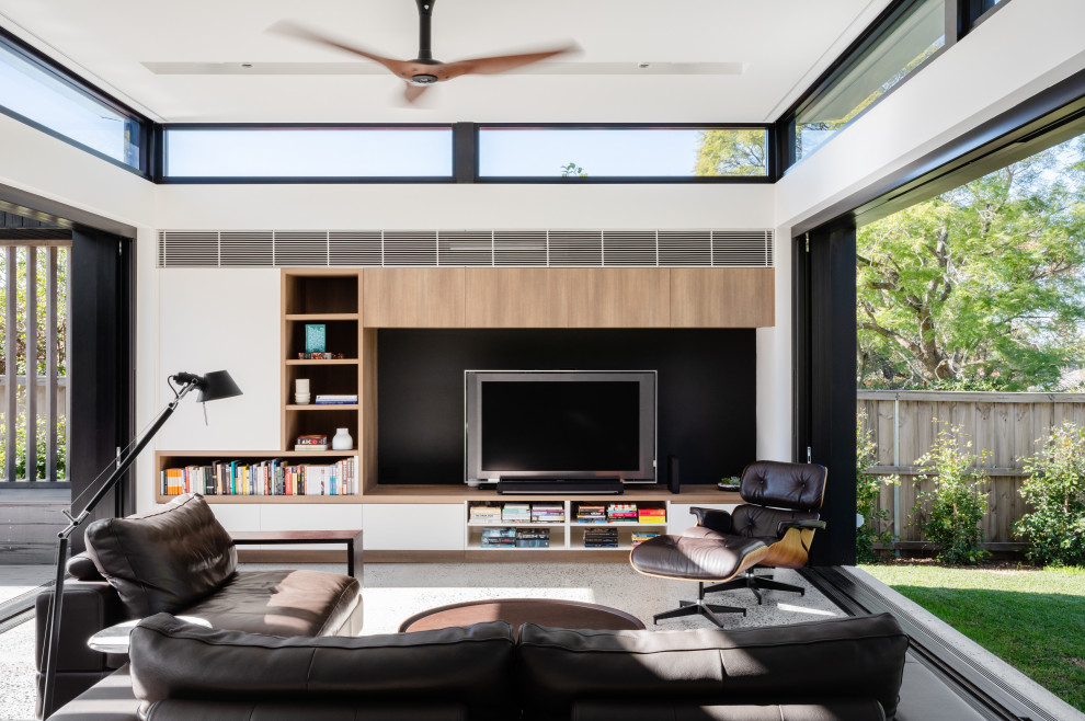 Foto de sala de estar abierta actual con paredes blancas, suelo de cemento, televisor independiente y suelo gris