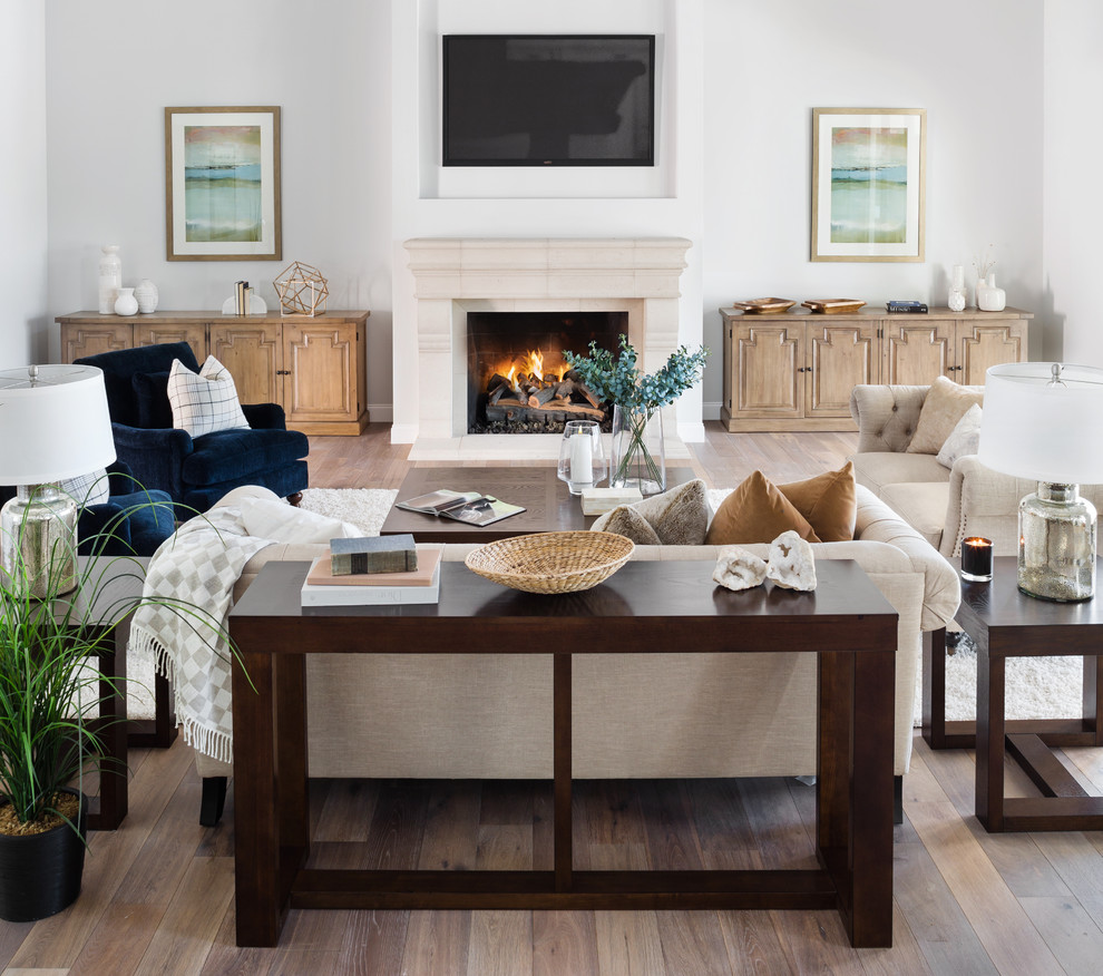 Inspiration for a transitional medium tone wood floor and brown floor family room remodel in Phoenix with white walls, a standard fireplace and a wall-mounted tv