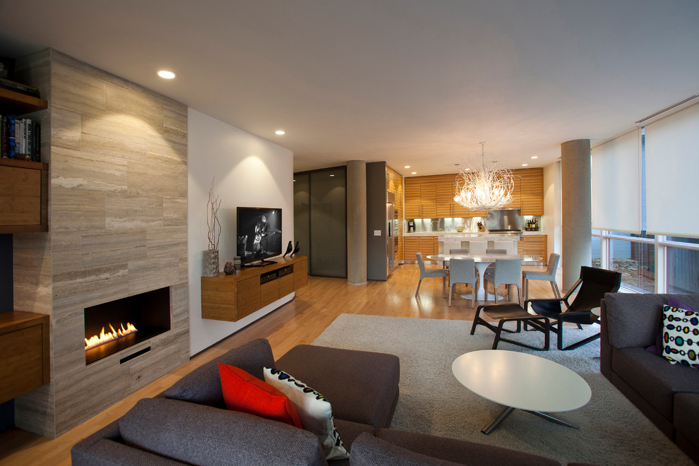Exemple d'une salle de séjour tendance ouverte avec un sol en bois brun, une cheminée ribbon, un manteau de cheminée en pierre et un téléviseur indépendant.