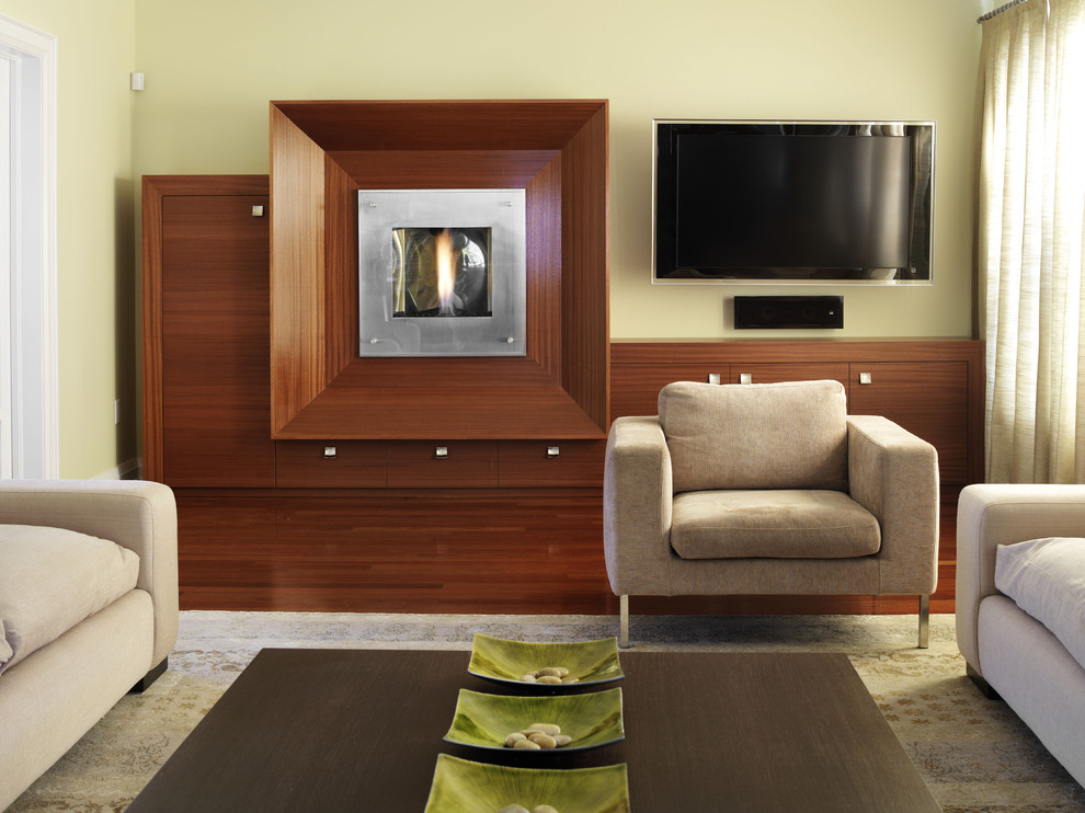 Inspiration pour une salle de séjour asiatique avec un mur vert, un manteau de cheminée en bois, un téléviseur fixé au mur, un sol en bois brun et une cheminée ribbon.
