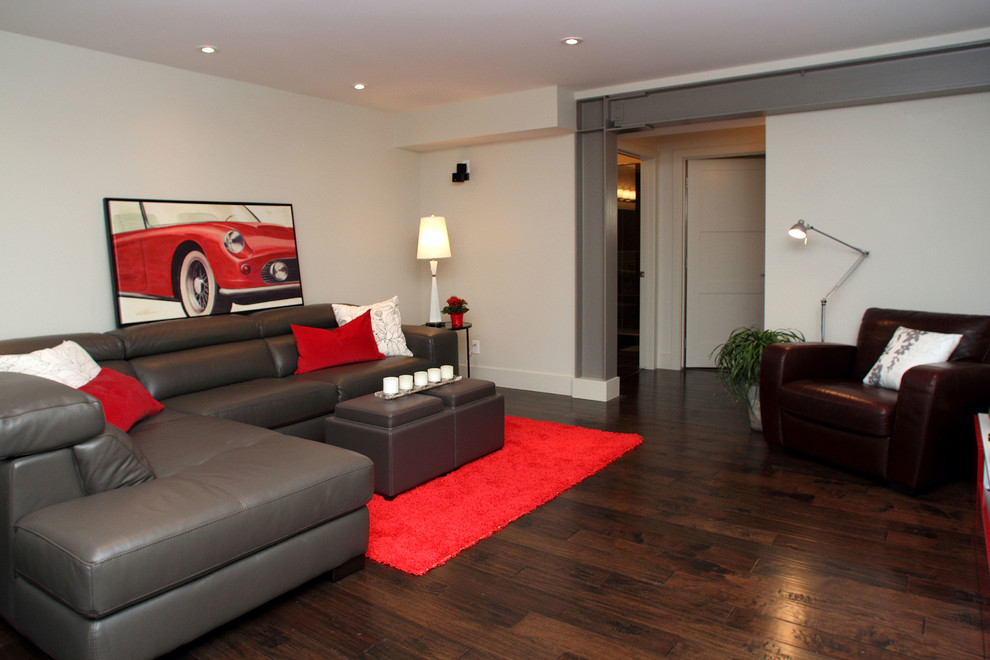 Großes, Abgetrenntes Modernes Wohnzimmer ohne Kamin mit grauer Wandfarbe, dunklem Holzboden und TV-Wand in Calgary