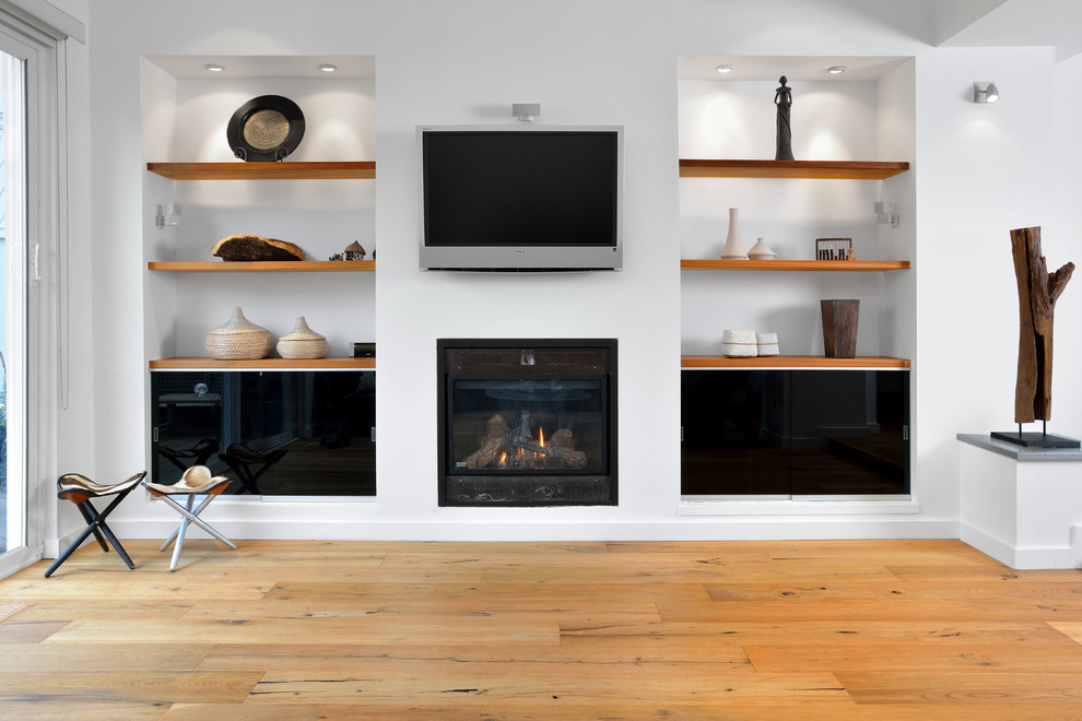 Inspiration for a modern open plan games room in Toronto with white walls, light hardwood flooring, a wall mounted tv and a ribbon fireplace.