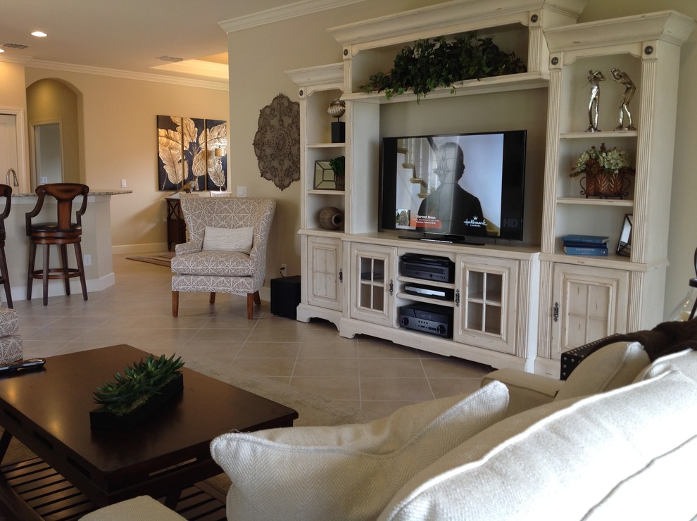 Imagen de sala de estar abierta clásica renovada de tamaño medio con paredes beige, suelo de piedra caliza y pared multimedia