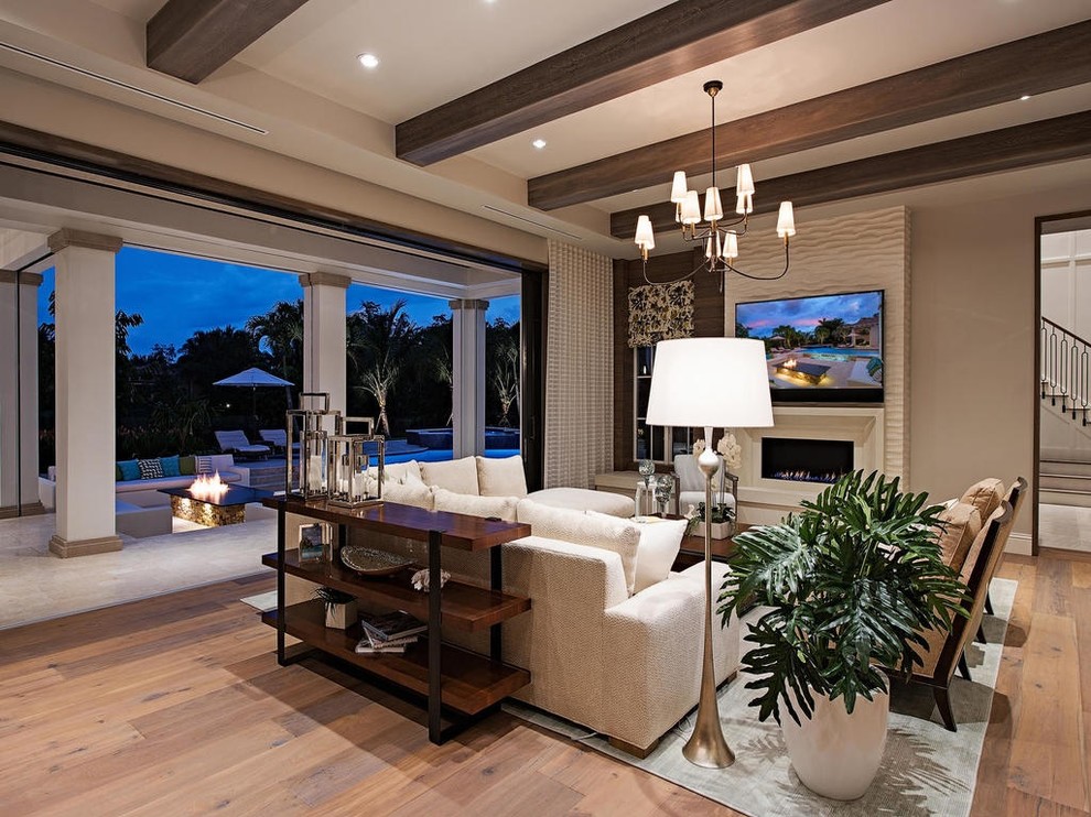 Family room - large transitional open concept medium tone wood floor family room idea in Miami with a wall-mounted tv, beige walls, a tile fireplace and a ribbon fireplace