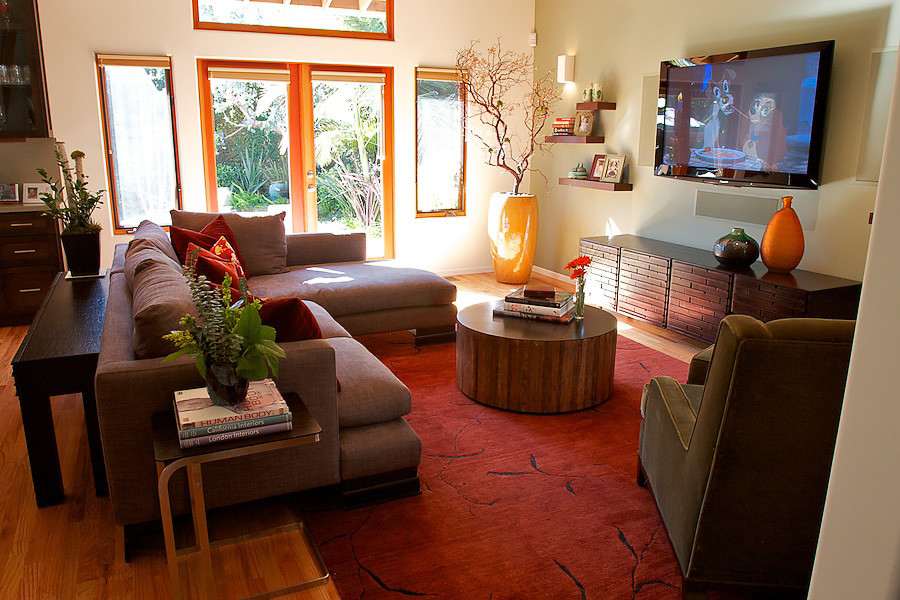 Foto de sala de estar abierta contemporánea grande sin chimenea con paredes beige, suelo de madera en tonos medios y televisor colgado en la pared