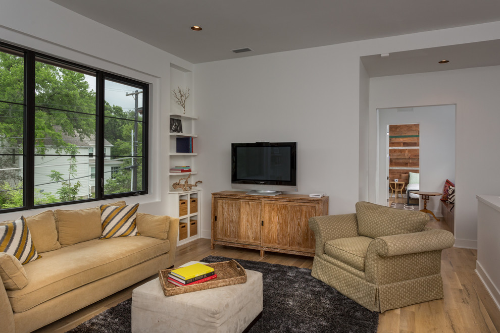 Immagine di un soggiorno chic con pareti bianche, parquet chiaro e TV autoportante