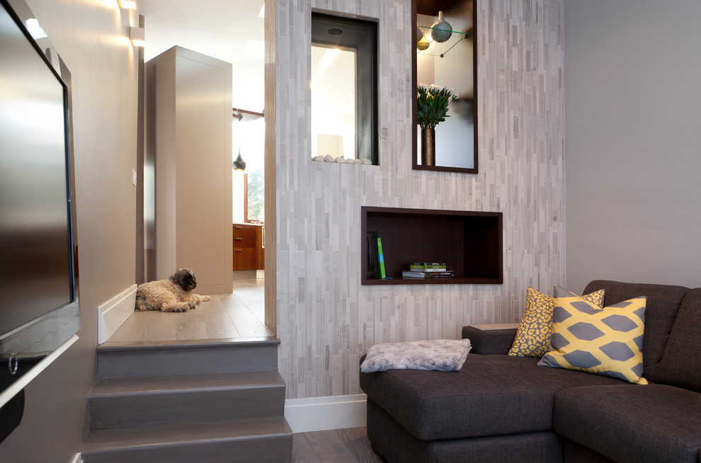 Immagine di un soggiorno minimalista di medie dimensioni e aperto con pareti grigie, pavimento in legno verniciato, nessun camino e TV a parete