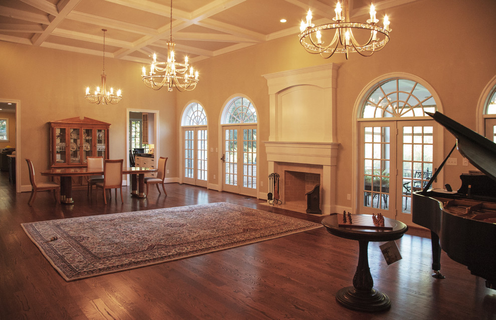 Пример оригинального дизайна: большая изолированная гостиная комната в классическом стиле с бежевыми стенами, паркетным полом среднего тона, стандартным камином и фасадом камина из дерева без телевизора