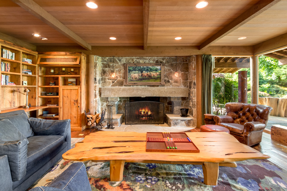 Geräumiges, Offenes, Fernseherloses Rustikales Wohnzimmer mit braunem Holzboden, Kamin und Kaminumrandung aus Stein in Seattle