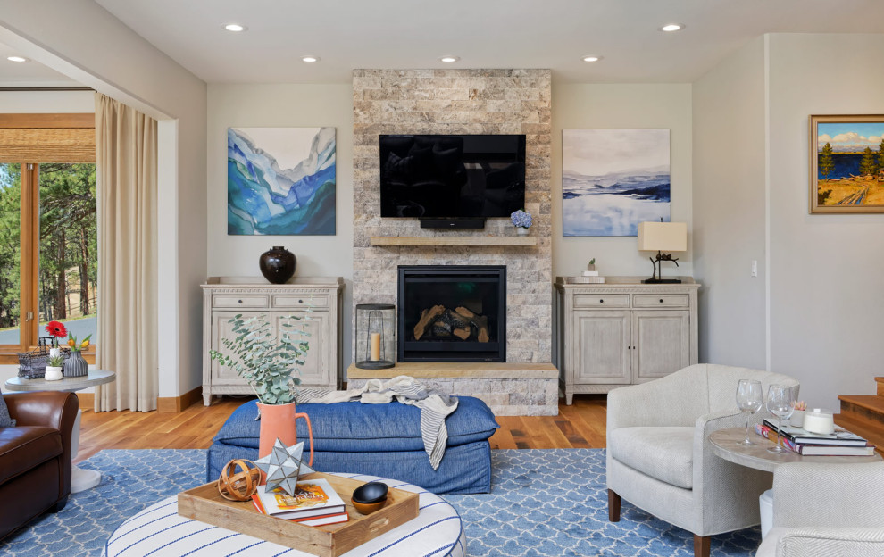 Réalisation d'une salle de séjour chalet de taille moyenne et ouverte avec un mur bleu, un sol en bois brun, une cheminée standard et un manteau de cheminée en métal.