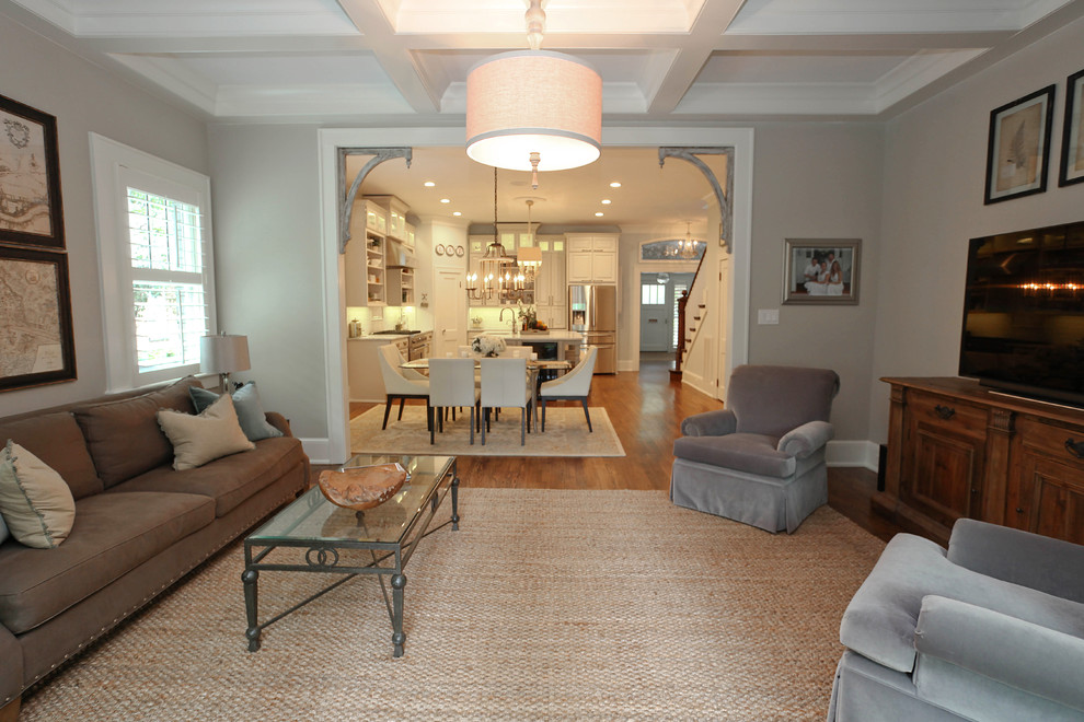 Offenes Uriges Wohnzimmer mit grauer Wandfarbe, braunem Holzboden und freistehendem TV in Charlotte