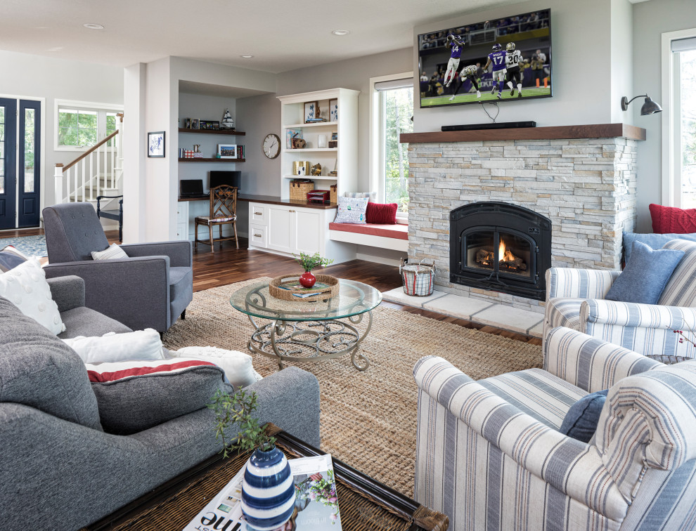 Mid-sized beach style open concept medium tone wood floor family room photo in Minneapolis with white walls, a wood stove, a stone fireplace and a wall-mounted tv