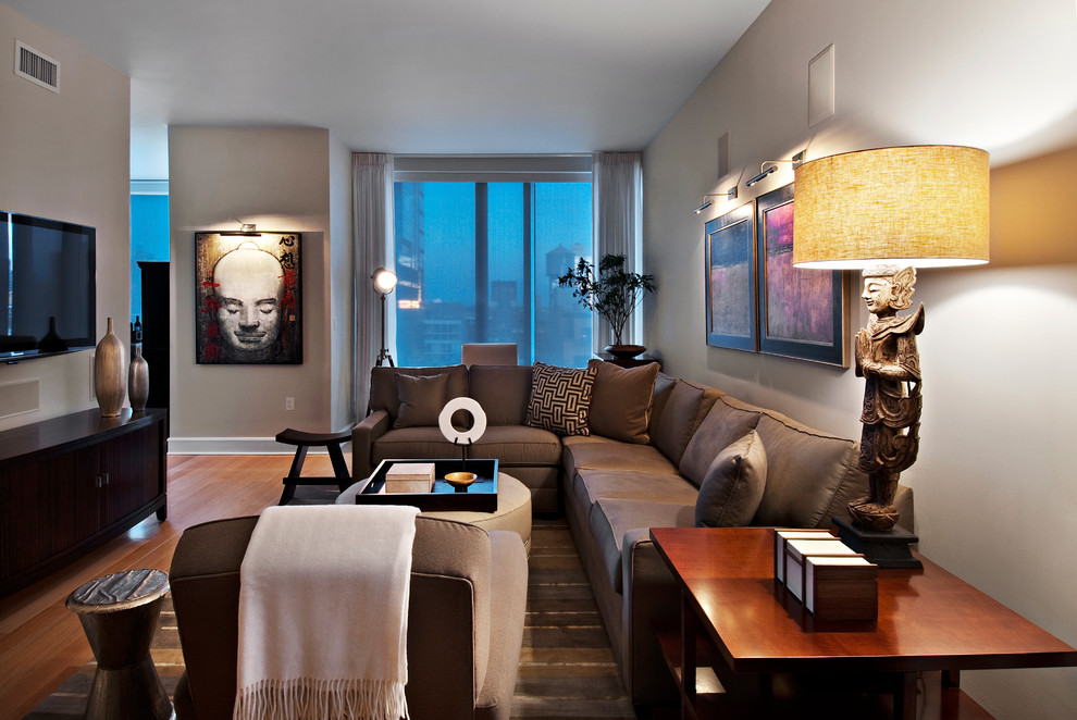 Esempio di un grande soggiorno tradizionale aperto con TV a parete, pareti beige e parquet chiaro