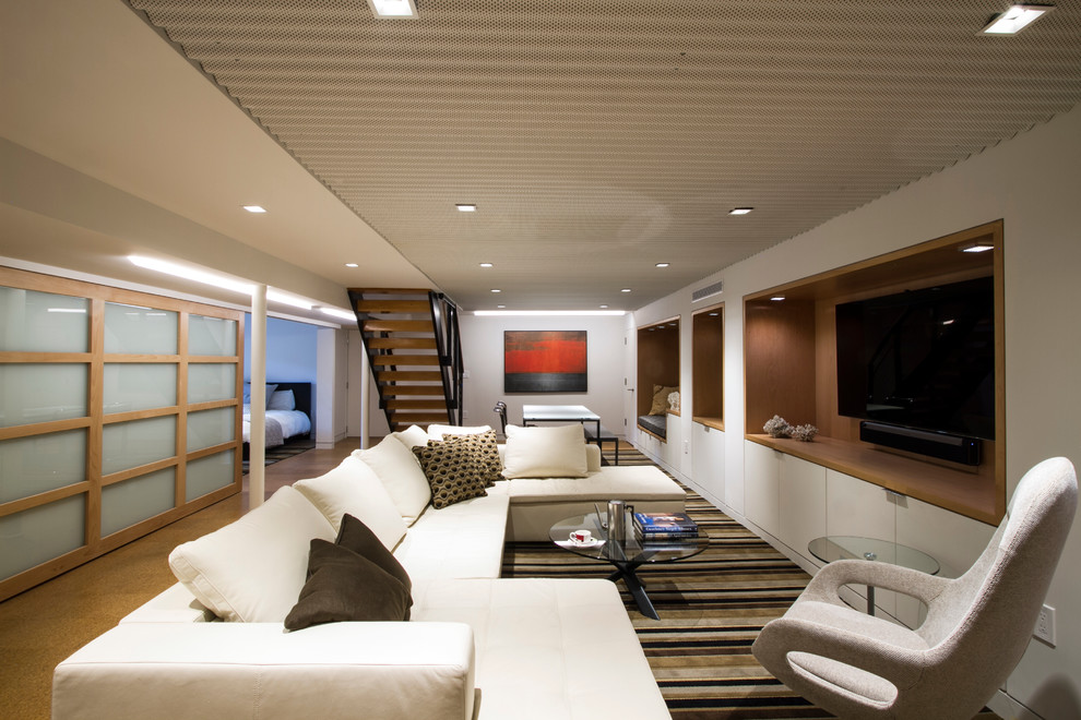 Aménagement d'une grande salle de séjour moderne fermée avec un mur blanc, un sol en liège, un téléviseur encastré, salle de jeu et un sol marron.