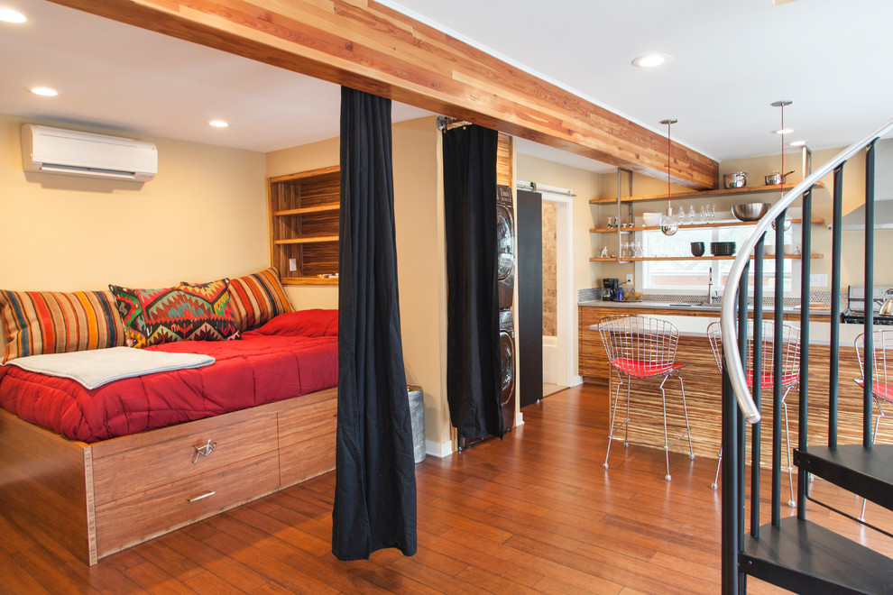 Modelo de sala de estar tipo loft actual pequeña con paredes beige y suelo de bambú