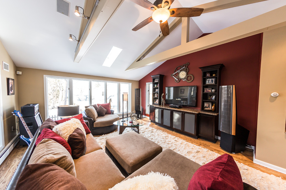 Diseño de sala de estar con rincón musical abierta tradicional renovada grande con paredes rojas, suelo de madera en tonos medios, pared multimedia y suelo multicolor