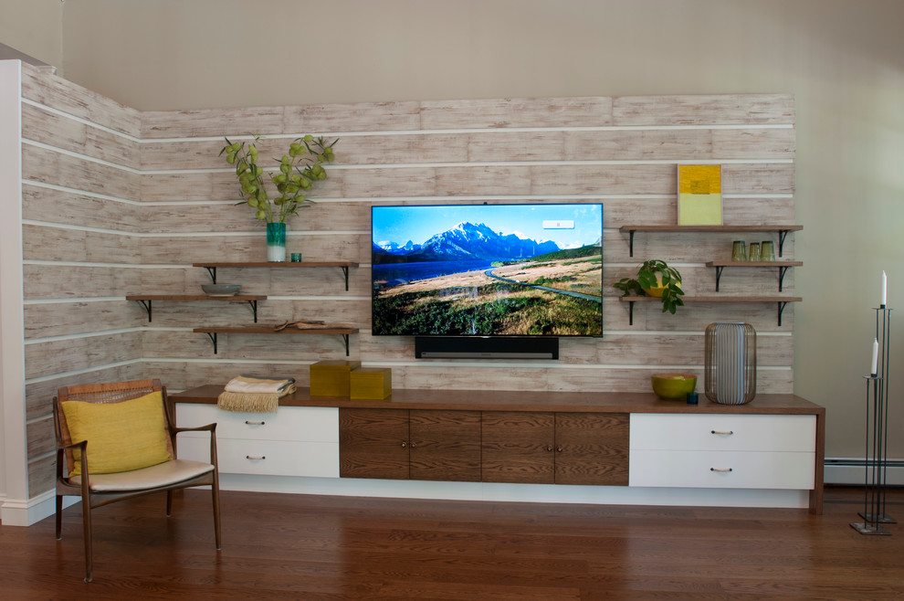 Ejemplo de sala de estar abierta retro grande con suelo de madera en tonos medios, televisor colgado en la pared y paredes grises