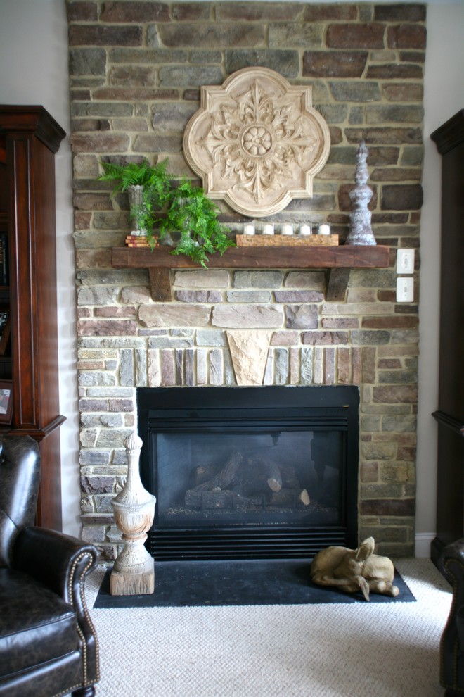 Idée de décoration pour une salle de séjour tradition avec un mur beige, une cheminée ribbon et un manteau de cheminée en pierre.