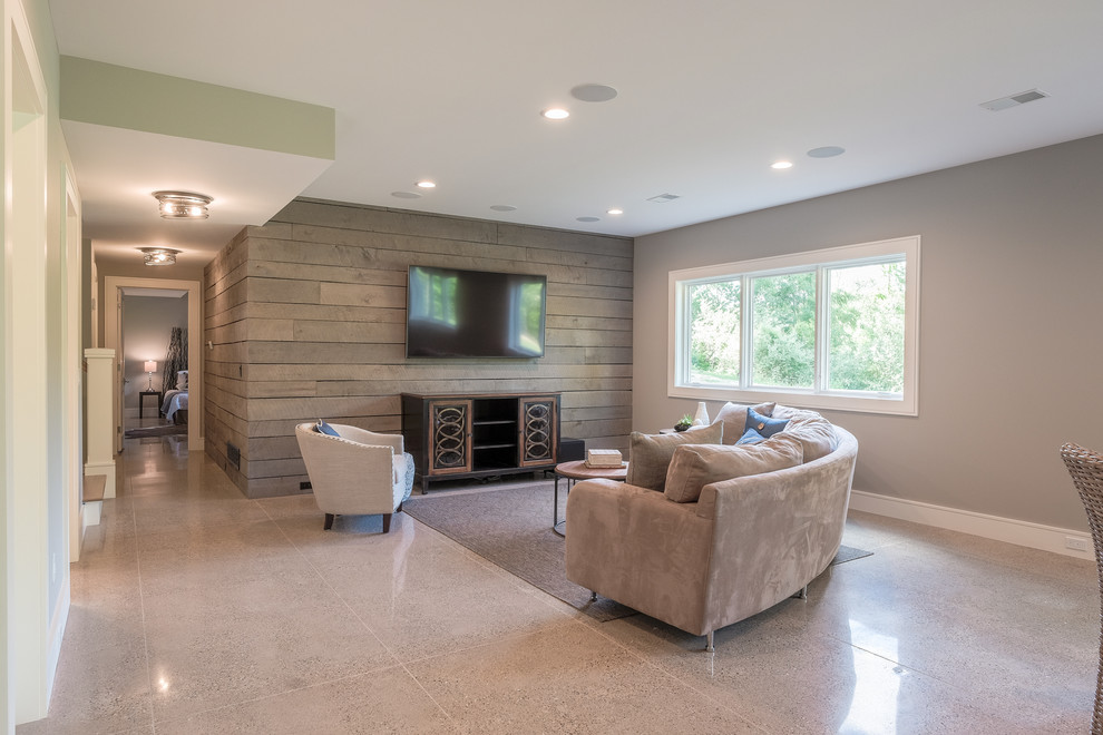 Diseño de sala de estar con barra de bar abierta tradicional renovada de tamaño medio sin chimenea con paredes grises, suelo de cemento, televisor colgado en la pared y suelo beige