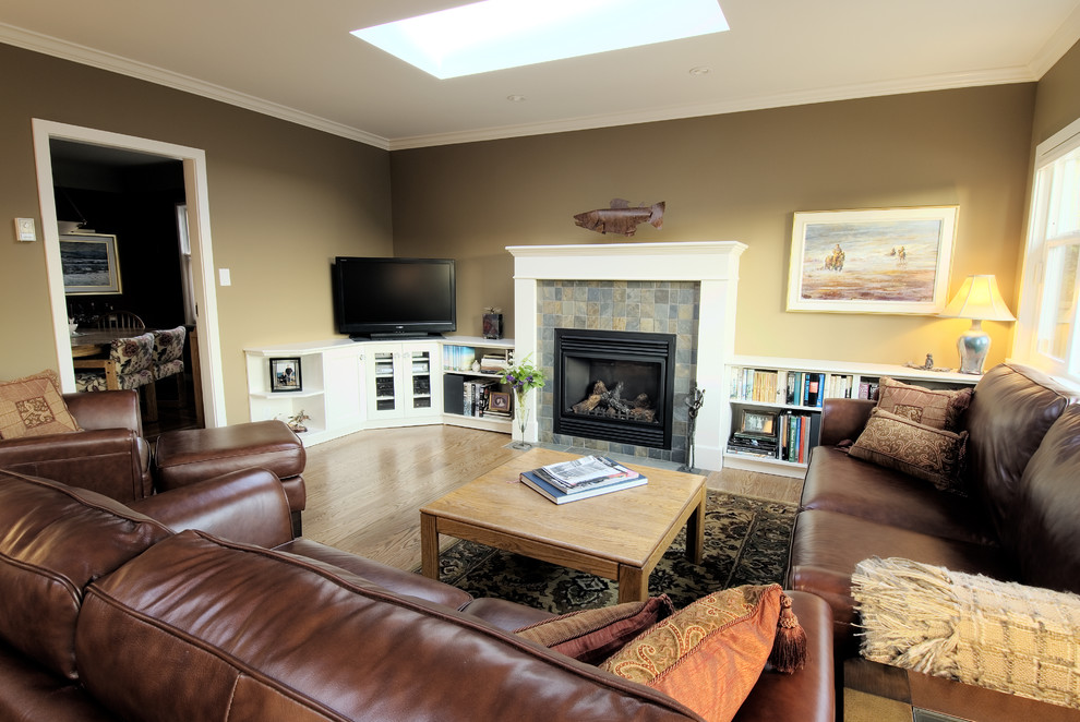 Cette image montre une salle de séjour traditionnelle de taille moyenne et ouverte avec un sol en bois brun, une cheminée standard, un manteau de cheminée en pierre, un téléviseur d'angle et un mur vert.