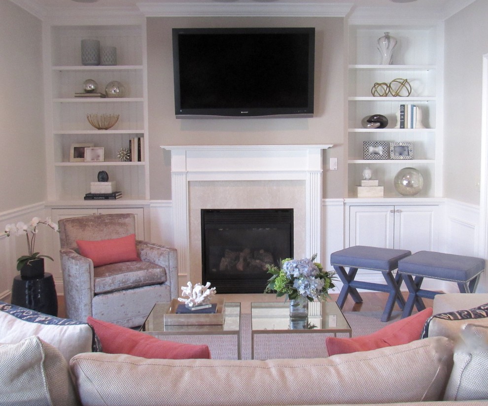 Modelo de sala de estar abierta tradicional renovada de tamaño medio con paredes grises, suelo de madera en tonos medios, todas las chimeneas, marco de chimenea de piedra y televisor colgado en la pared