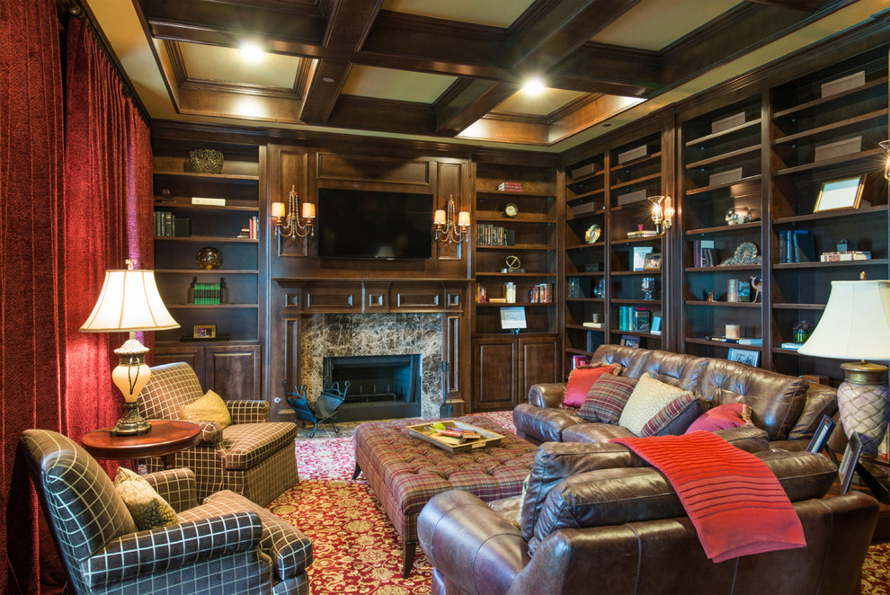 На фото: изолированная гостиная комната в классическом стиле с с книжными шкафами и полками, стандартным камином, фасадом камина из камня и телевизором на стене