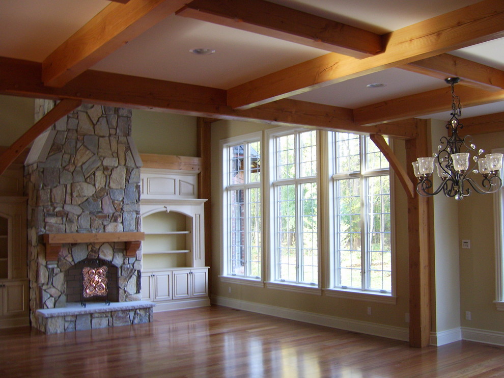 Mid-sized mountain style enclosed light wood floor and brown floor family room photo in Detroit with green walls, a standard fireplace, a stone fireplace and no tv