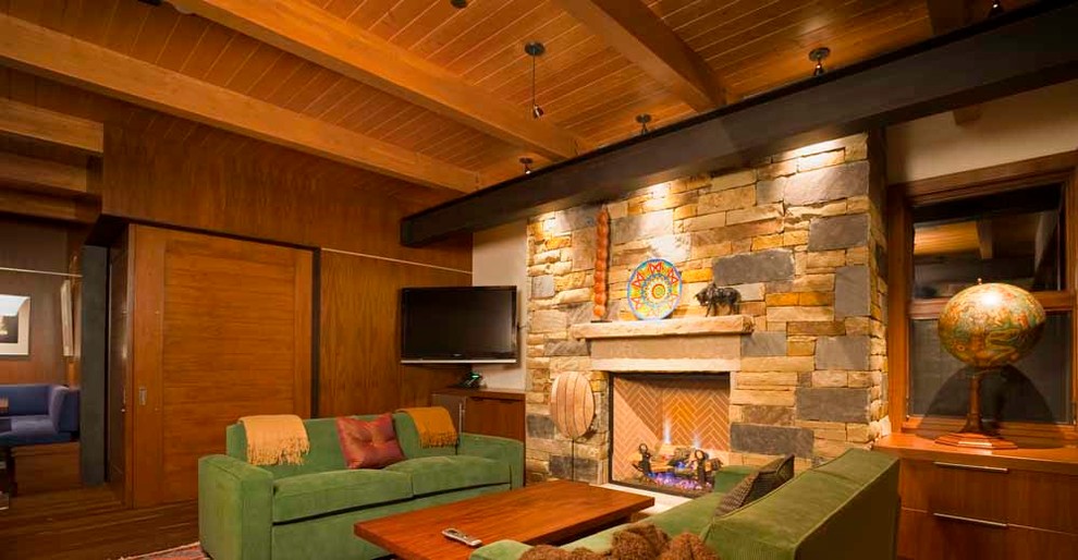 Идея дизайна: большая изолированная гостиная комната в стиле модернизм с паркетным полом среднего тона, стандартным камином, фасадом камина из камня и телевизором в углу