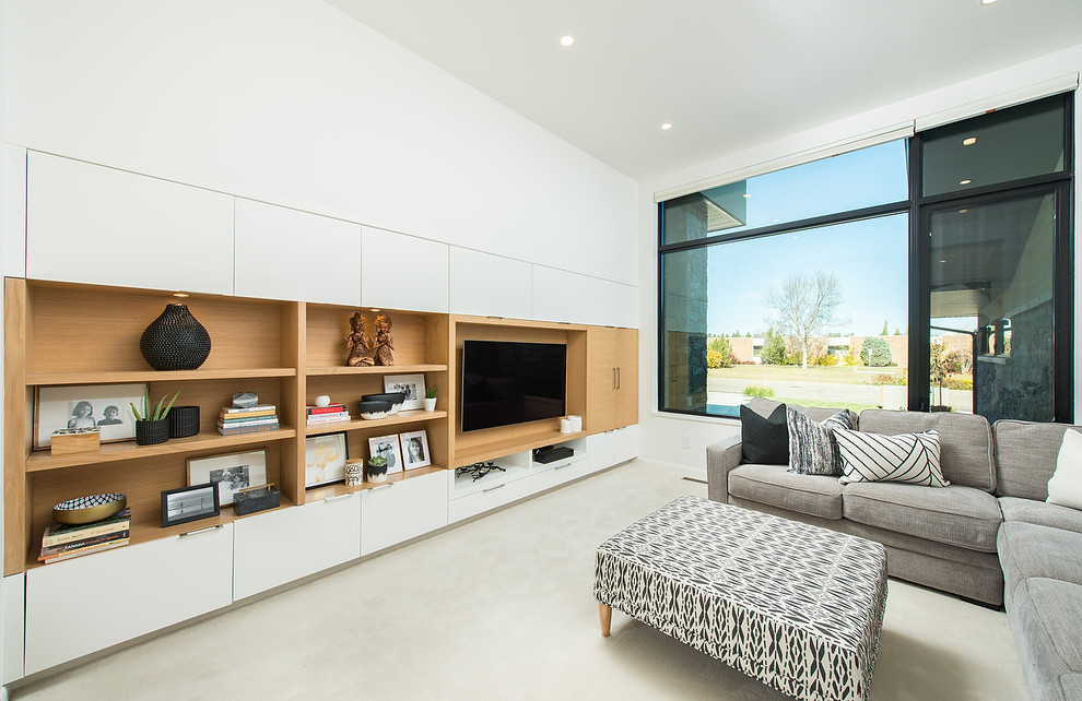 Стильный дизайн: гостиная комната в современном стиле с белыми стенами, ковровым покрытием, телевизором на стене и белым полом - последний тренд