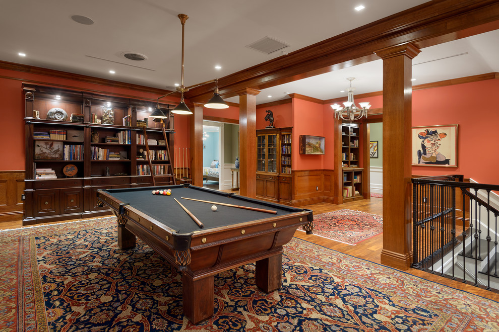 Klassisches Wohnzimmer mit roter Wandfarbe, braunem Holzboden und braunem Boden in Orlando