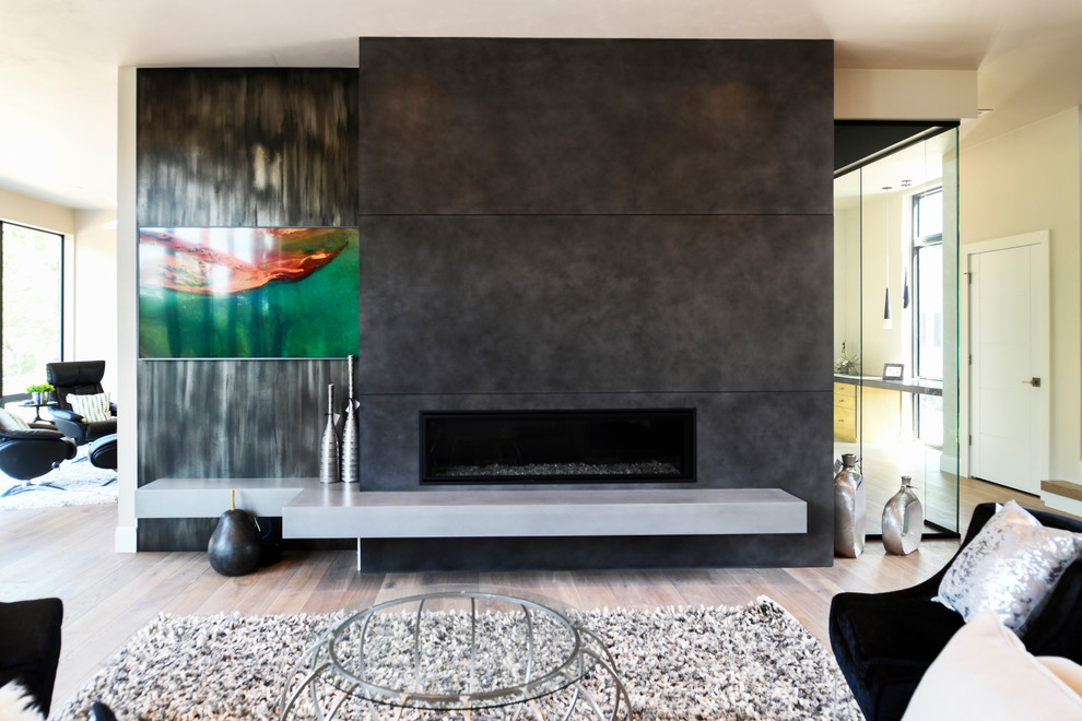 ミルウォーキーにある巨大なコンテンポラリースタイルのおしゃれなオープンリビング (淡色無垢フローリング、標準型暖炉、コンクリートの暖炉まわり、茶色い床) の写真