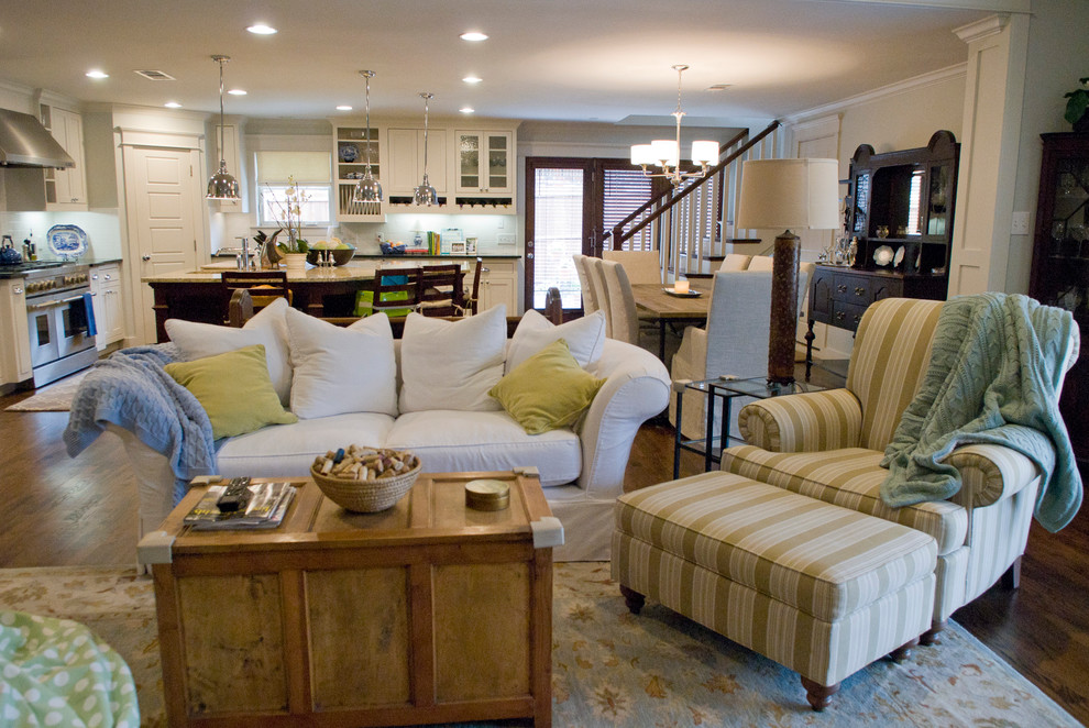 Diseño de sala de estar abierta de estilo americano con paredes azules, suelo de madera en tonos medios, todas las chimeneas, marco de chimenea de piedra y televisor colgado en la pared