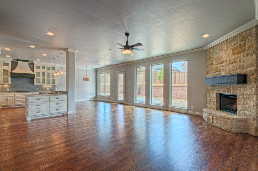 Traditional games room in Oklahoma City with grey walls, medium hardwood flooring, a corner fireplace and a stone fireplace surround.