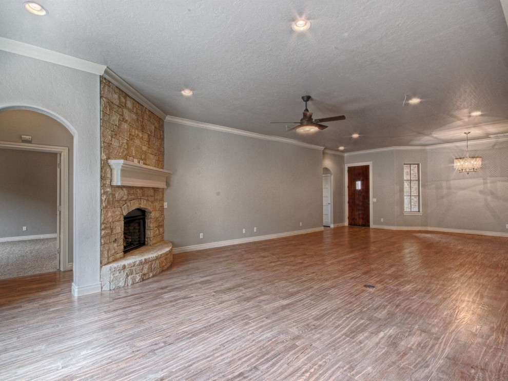 Inspiration for a traditional games room in Oklahoma City with grey walls, medium hardwood flooring, a corner fireplace and a stone fireplace surround.