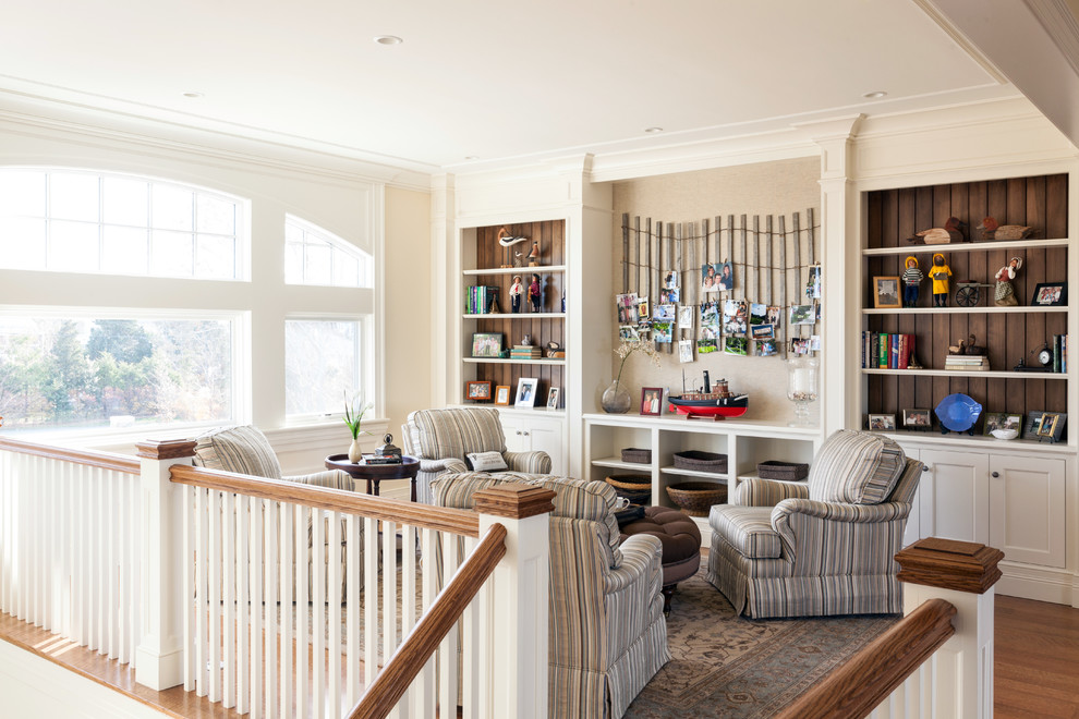 Foto de sala de estar tipo loft costera sin chimenea y televisor con paredes beige y suelo de madera en tonos medios