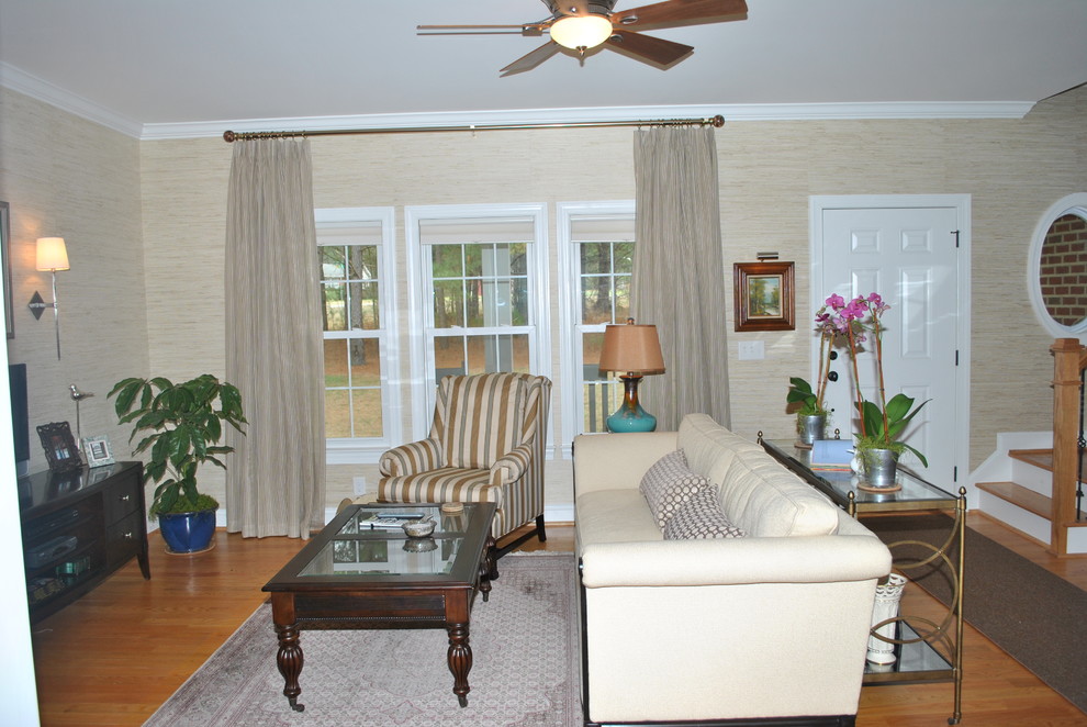 Mid-sized elegant enclosed medium tone wood floor family room photo in Raleigh with beige walls and a tv stand