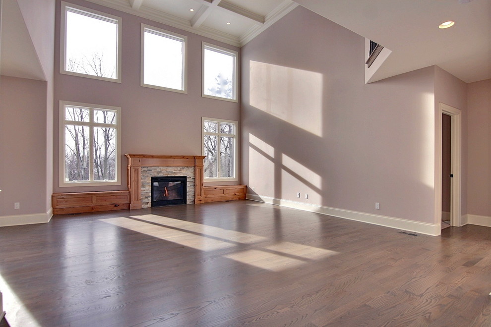 Imagen de sala de estar abierta bohemia extra grande con suelo de madera clara y marco de chimenea de madera