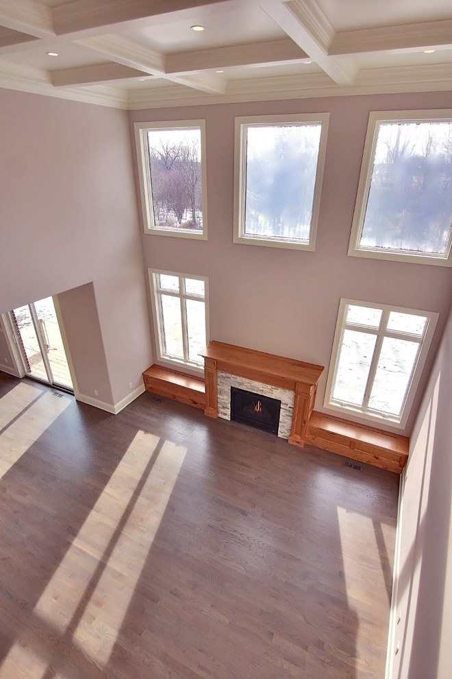 Diseño de sala de estar abierta ecléctica extra grande con suelo de madera clara y marco de chimenea de madera