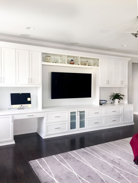 Diseño de sala de estar abierta tradicional renovada grande sin chimenea con paredes blancas, suelo de madera oscura, televisor colgado en la pared y suelo marrón
