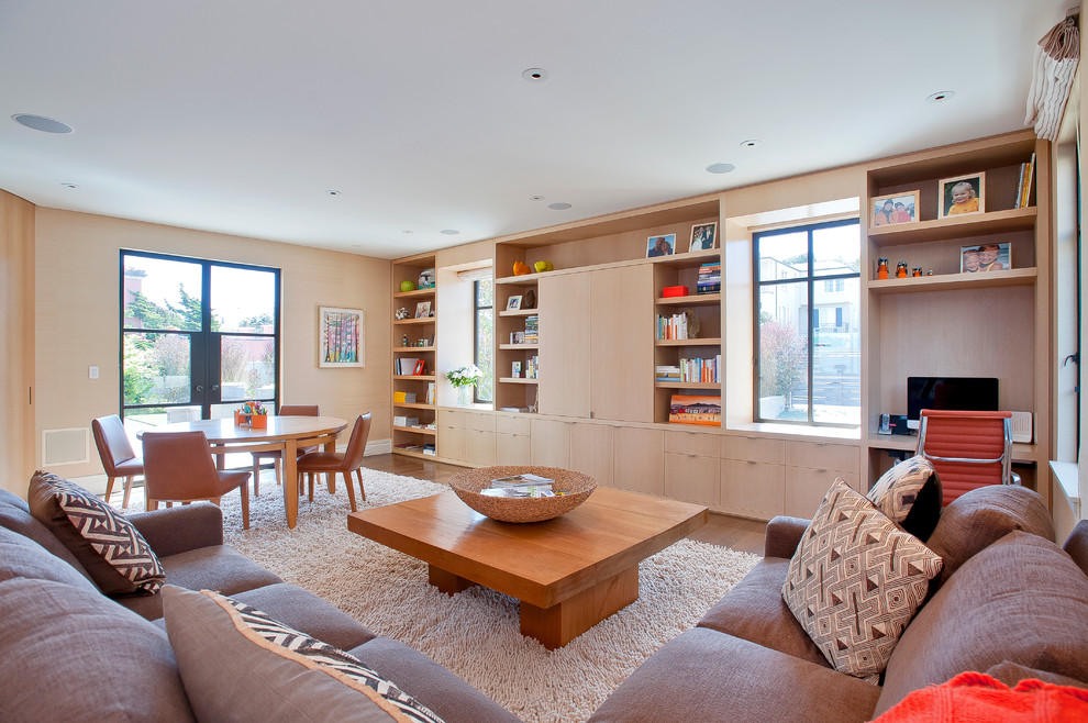Foto de sala de estar abierta actual con paredes beige y suelo de madera en tonos medios