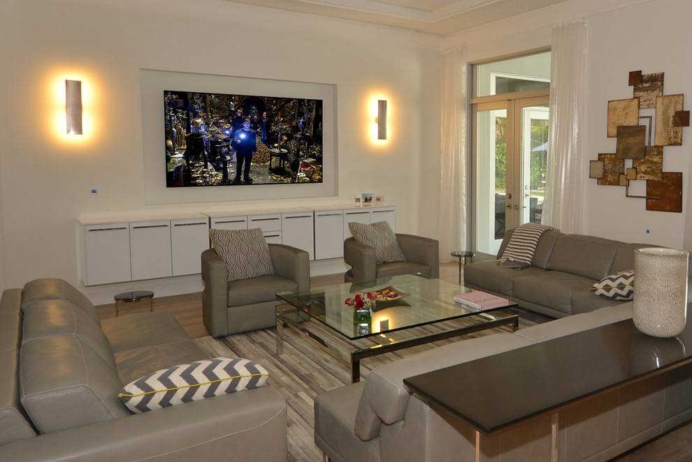 This is an example of a large contemporary open plan games room in Miami with white walls, medium hardwood flooring, no fireplace and a built-in media unit.