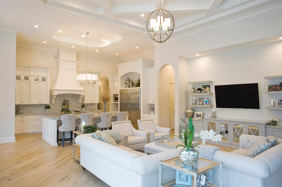 Großes, Offenes Mediterranes Wohnzimmer mit beiger Wandfarbe, braunem Holzboden und TV-Wand in Miami